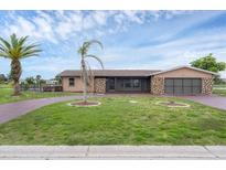 Single story home with a stone facade and well-manicured lawn at 76 Caddy Rd, Rotonda West, FL 33947