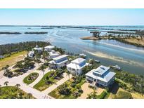 Aerial view of waterfront homes with private docks and lush landscaping at 13330 Anglers Way, Placida, FL 33946