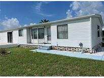 White mobile home with steps and landscaping at 8485 Nighthawk Dr, Englewood, FL 34224