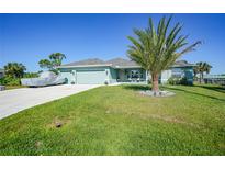 Single-story house with two-car garage and lush lawn at 9194 Impala Cir, Port Charlotte, FL 33981