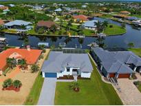 Aerial view of a canal-front home and neighborhood at 8250 Arlewood Cir, Port Charlotte, FL 33981