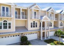 Tan three-story townhouses with white garage doors and balconies at 10380 Longshore Rd # 77, Placida, FL 33946