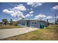 Ranch-style home with light blue exterior and a spacious front yard at 22216 Midway Blvd, Port Charlotte, FL 33952