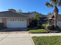 Inviting exterior of a two-story house with a two-car garage and lush landscaping at 2095 Lynx Run, North Port, FL 34288