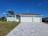New construction home with three-car garage and paver driveway at 2170 Doolittle Ln, Port Charlotte, FL 33953