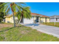 Single story home with a palm tree and driveway at 285 Mark Twain Ln, Rotonda West, FL 33947