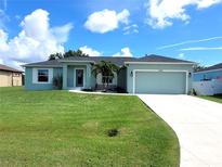 Charming light teal house with a two-car garage at 12112 Helios Ave, Port Charlotte, FL 33981