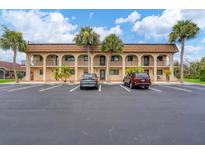 Building exterior featuring Spanish-style architecture and ample parking at 235 Rotonda Blvd W # C203, Rotonda West, FL 33947
