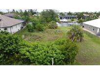 Waterfront vacant lot, surrounded by established homes and lush landscaping at 8356 Tecumseh Cir, Port Charlotte, FL 33981