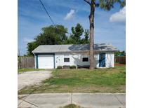 Cozy one-story home with a detached garage and a small front yard at 1170 Pine St, Englewood, FL 34223