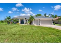 Single-story home with a two-car garage and well-maintained lawn at 423 Boundary Blvd, Rotonda West, FL 33947