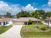 Single-story house with a two-car garage and landscaped yard at 1867 Neptune Dr, Englewood, FL 34223