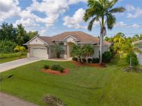 Single-story home with a two-car garage and lush landscaping at 14089 Newson Ln, Port Charlotte, FL 33981