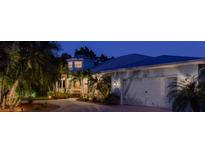 Charming home with a two-car garage, lush landscaping, and walkway to the front door at twilight at 200 Capstan Dr, Placida, FL 33946