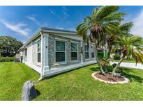 Single-story home with stone accents and a palm tree in the front yard at 624 Blackburn Blvd, North Port, FL 34287