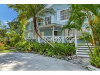 Charming two-story home with a wrap-around porch and lush landscaping at 1730 Padre Ln, Englewood, FL 34223