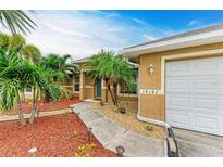 Front entry with walkway, landscaping, and a white door at 14143 Saul Ln, Port Charlotte, FL 33981