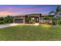 One-story house with a screened patio and lush lawn at 191 Brig W Cir, Placida, FL 33946