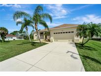 Single-story home with attached garage and palm trees in the front yard at 127 White Marsh Ln, Rotonda West, FL 33947