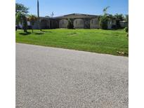 Ranch-style home with a well-maintained lawn at 1455 Crest Dr, Englewood, FL 34223