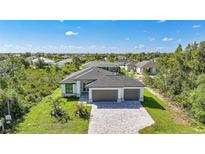 New construction home with paved driveway, two-car garage, professional landscaping, and modern design at 9262 Genesee St, Port Charlotte, FL 33981
