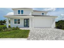 Two-story home with gray paver driveway and landscaped lawn at 5240 Willow Lake Ct, Sarasota, FL 34233