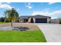 House exterior with palm tree, driveway, and landscaping at 9273 Carnation Ave, Englewood, FL 34224