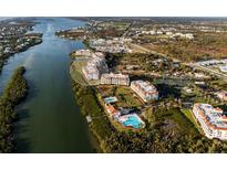 Aerial view of waterfront condo community with lush landscaping, pools, and river access at 11160 Hacienda Del Mar Blvd # D-205, Placida, FL 33946