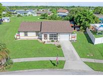 Well-maintained single-story home with a large front yard, paved driveway, and charming landscaping at 6367 Facet Ln, Port Charlotte, FL 33981