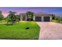 Single-story home with a two-car garage and lush landscaping at 15608 Lakeland Cir, Port Charlotte, FL 33981