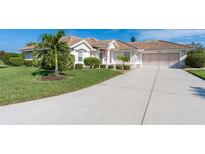 Single-story home with tile roof, landscaped yard, and driveway at 8216 Parkside Dr, Englewood, FL 34224