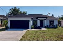 Charming one-story home with dark gray roof, black trim, and a well-manicured lawn at 235 Albatross Rd, Rotonda West, FL 33947