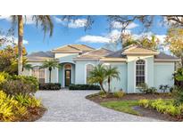 Stunning light blue home with a paved driveway and lush landscaping at 29 St John Blvd, Englewood, FL 34223