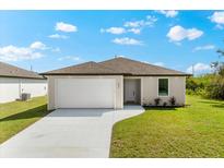 One-story home with a white exterior, a brown roof, and a driveway at 590 Rutland Cir, Port Charlotte, FL 33954