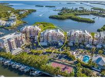 Aerial view of waterfront community with tennis court and pool at 13313 Gasparilla Rd # C205, Placida, FL 33946
