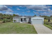 Single-story home with attached garage and grassy yard at 19196 Raymond Ave, Port Charlotte, FL 33954