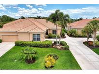 Single-story home with tile roof, two-car garage, and lush landscaping at 2844 Myakka Creek Ct, Port Charlotte, FL 33953