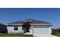 Charming single-story home with a gray roof, an attached two-car garage, and a well-maintained lawn at 450 Albatross Rd, Rotonda West, FL 33947