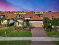 Attractive single story home with a brick driveway and terracotta roof at 25122 Spartina Dr, Venice, FL 34293