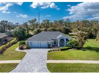 House exterior featuring a three-car garage and a nicely landscaped yard at 110 Abercrombie Ave, Englewood, FL 34223