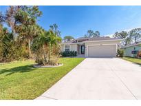 Single-story home with a two-car garage and well-manicured lawn at 152 Apollo Dr, Rotonda West, FL 33947