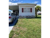 Charming single-wide mobile home with a manicured lawn at 5560 Holiday Park Blvd, North Port, FL 34287