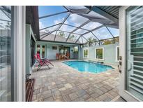 Inviting pool area with covered patio, lounge chairs, and lush landscaping at 137 Wahoo Dr, Rotonda West, FL 33947