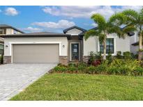 Two-story house with attached garage and landscaping at 19536 Fishhawk Trl, Venice, FL 34293