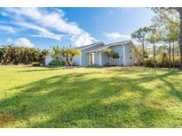 Light blue house with gray roof, spacious lawn at 5214 Norlander Dr, Port Charlotte, FL 33981