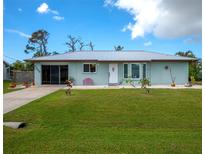 Charming single story home with a metal roof and well-manicured lawn at 7209 Mamouth St, Englewood, FL 34224