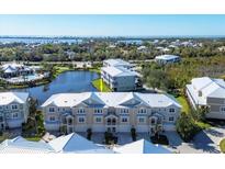 Aerial view of waterfront townhouses with a community pool and lush landscaping at 10325 Longshore Rd # 20, Placida, FL 33946