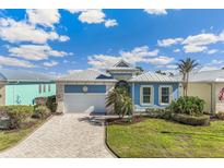 Beautiful light blue home with metal roof, 2-car garage, and landscaped yard at 10399 Coquina Ct, Placida, FL 33946