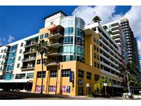 Modern urban condo building with yellow facade and parking garage at 1120 E Kennedy Blvd # 1423, Tampa, FL 33602