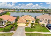 Aerial view of a yellow house with lake access in a Florida community at 1985 Coconut Palm Cir, North Port, FL 34288